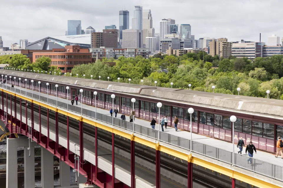 The Washington St Bridge in Minneapolis is shown with downtown Minneapolis in the background.